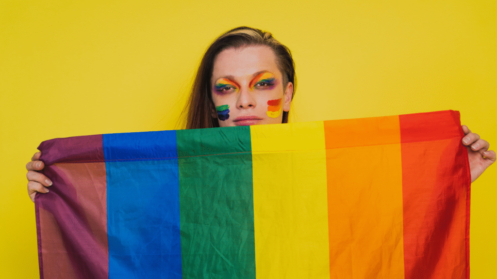 Banner _ Mulher segurando uma bandeira LGBT - Psicologia no Esporte
