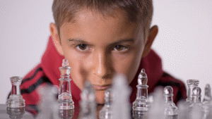 Banner _ Menino concentrado em um tabuleiro de xadrez - Psicologia no Esporte