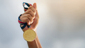 Banner _ Mão segurando uma medalha - Psicologia no Esporte